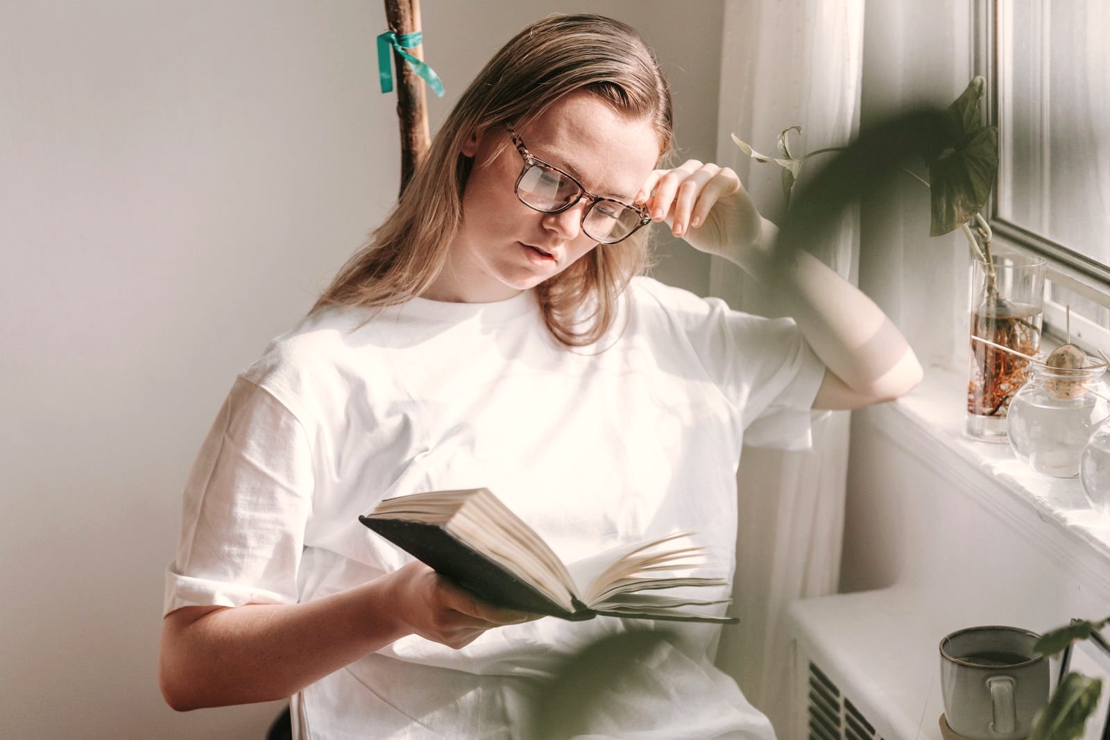 Woman reading quietly by a sunlit window